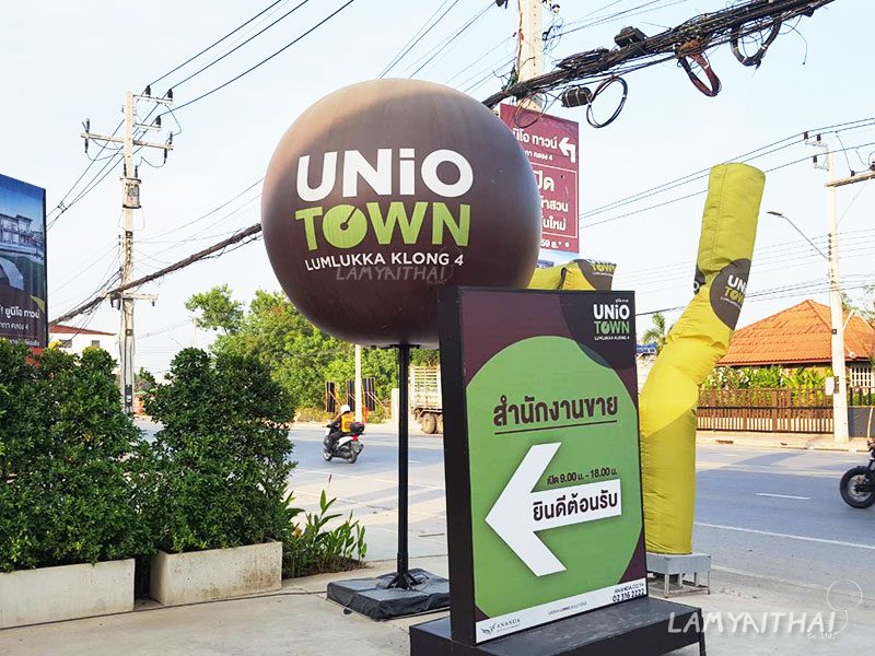 บอลลูนโฆษณาสีน้ำตาลพิมพ์โลโก้ UNiO Town หน้าสำนักงานขายโครงการบ้าน