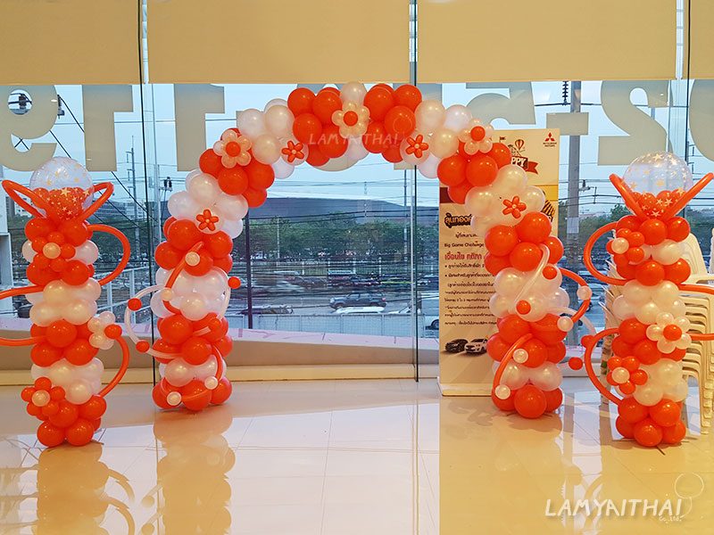 ซุ้มลูกโป่งสีส้มขาวพร้อมเสาลูกโป่งตกแต่งงานอีเวนต์ในโชว์รูมมิตซูบิชิ