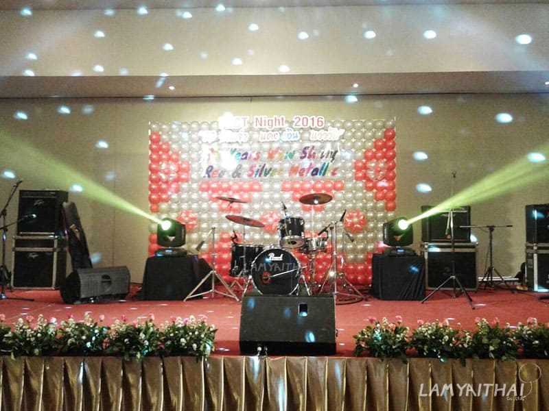 กำแพงลูกโป่งสีแดงขาวตกแต่งฉากหลังเวทีดนตรี งานเลี้ยงบริษัทในโรงแรม