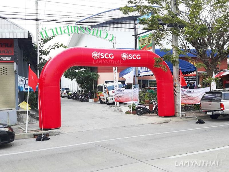 ซุ้มพองลมสีแดงพิมพ์โลโก้ SCG ติดตั้งริมถนนในงานกิจกรรมชุมชน