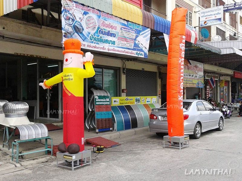 ตุ๊กตาโบกสีเหลืองแดงคู่สกายทูปสีส้ม หน้าร้านวัสดุหลังคา