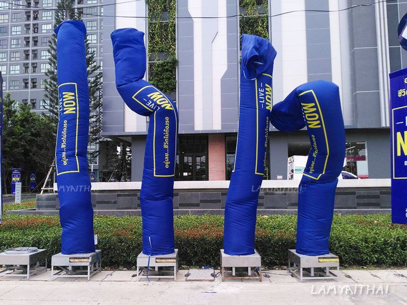 ท่อผ้าสกายทูปสีน้ำเงินพิมพ์ข้อความ Live Now เรียงแถวหน้าโครงการคอนโด